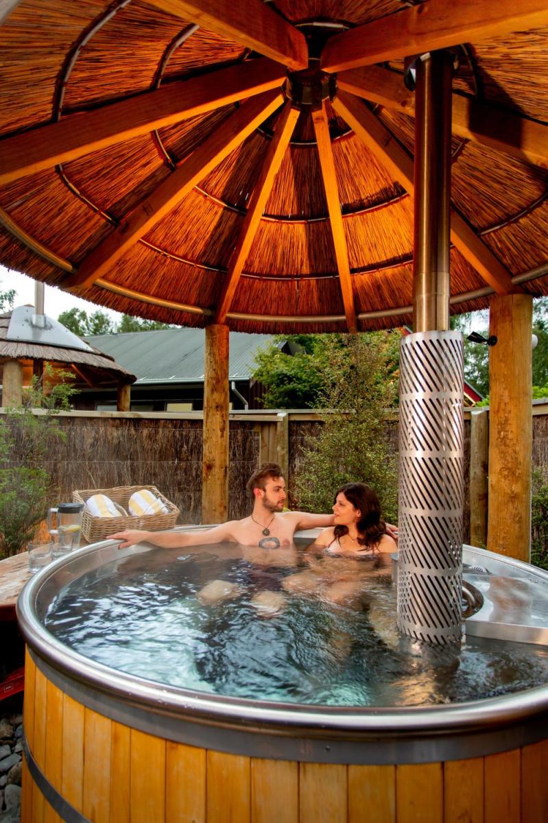 Guests relaxing in a wood-fired hot tub at Hanmer Springs TOP 10 Holiday Park